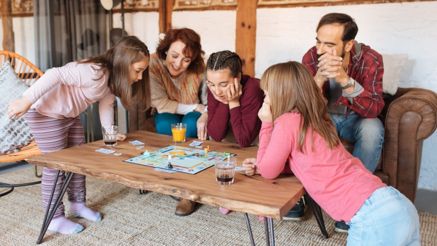Happy family at home in the couch playing classic table games Gradiva Slovenskega katehetskega urada za <EM>33. nedeljo med letom</EM>: <strong>Skupaj in z Njim</strong>