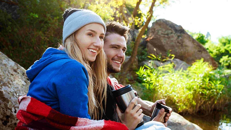young-couple-sitting-rock-canyon-smiling-drinking-tea (unsplash) <strong>Poletje</strong> − priložnost <em>za vaju</em>: Duhovna spodbuda za zakonce